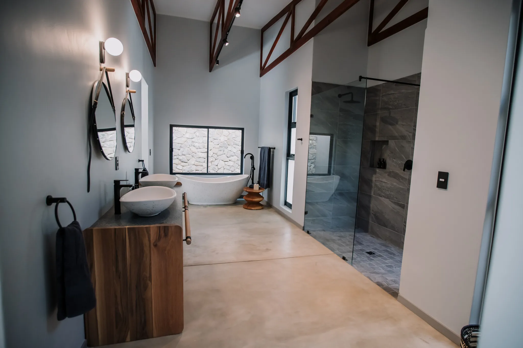 An elegant bathroom with two sinks, large shower and a bath.